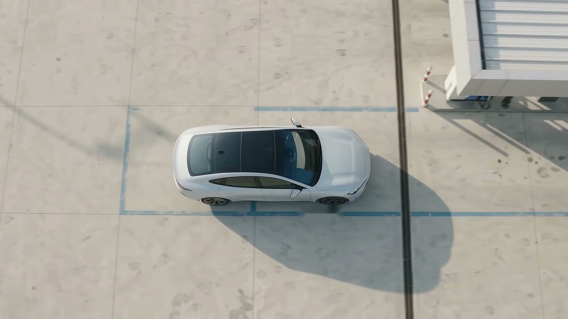 A car arriving at a service centre, seen from above, with no barrier in its path