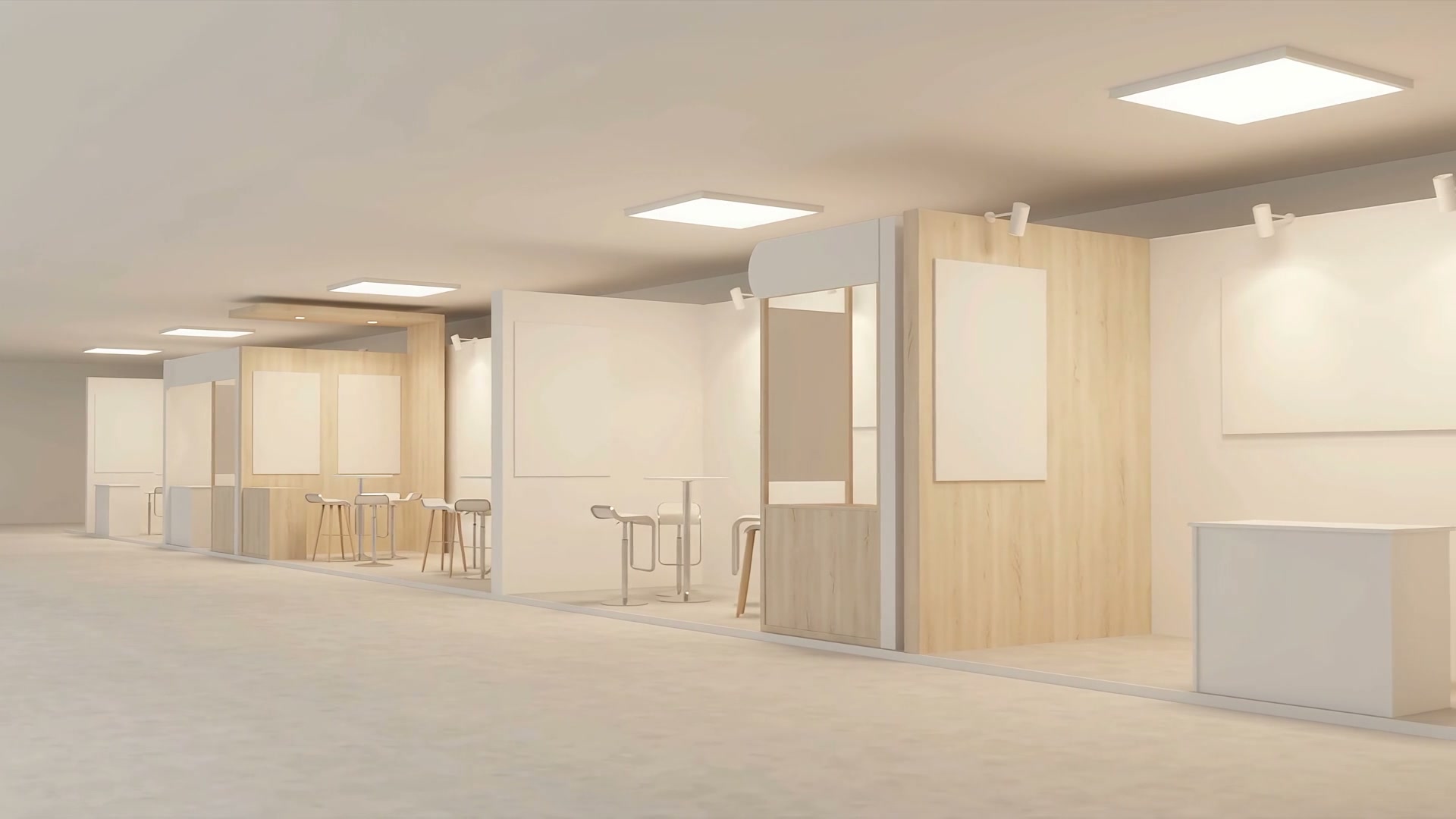An aisle of lit exhibition stands with no visitors at them